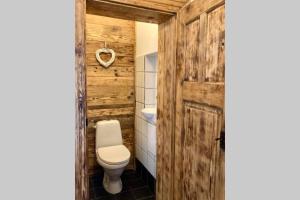 a bathroom with a toilet and a wooden door at Apartament Stara Kamienica 1930r. in Kłodzko