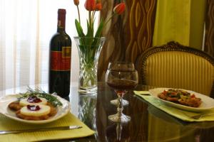 a table with two plates of food and a bottle of wine at Hotel Polonia in Namysłów