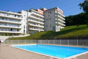 uma piscina em frente a um edifício em 2 pièces avec Terrasse, Piscine, parking privatif em Besançon