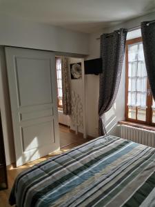 a bedroom with a bed and a sliding door at La Ruche Cantalienne in Saint-Étienne-de-Chomeil