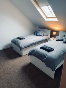 two beds in a attic bedroom with a skylight at Cliffview Apartment in Arbroath