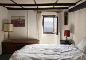 a bedroom with a white bed and a window at Casa al Vento in Bidogno