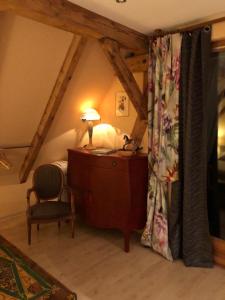 a bedroom with a bed and a desk and a chair at La maison rouge in Ostheim