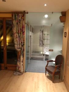 a living room with a chair and a sliding glass door at La maison rouge in Ostheim
