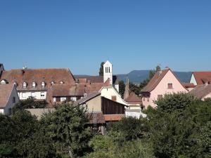 a group of buildings with a clock tower in a town at La maison rouge in Ostheim