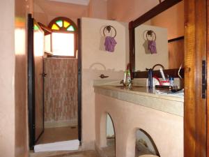 baño con lavabo y encimera con espejo en Riad Sesame, en Marrakech