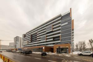 um grande edifício com carros estacionados num parque de estacionamento em Apartamenty Jurowiecka em Bialystok