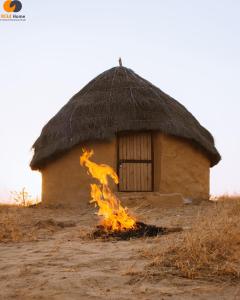 a small hut with a fire in front of it at Room Factory Hotels Chhatrel in Jaisalmer