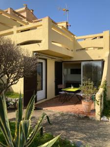 a house with a patio with a table in it at Maison de la Mer in Port Leucate