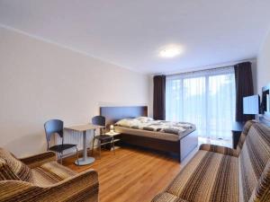 a bedroom with a bed and a table and chairs at Dafne 2 in Niechorze
