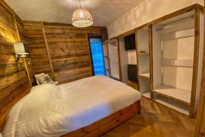 een slaapkamer met een groot bed en een kroonluchter bij Gîte avec jacuzzi privatif in Crots