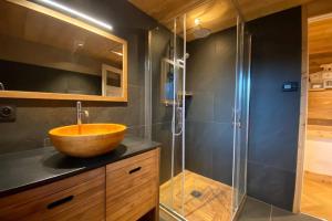 a bathroom with a wooden sink and a shower at Gîte avec jacuzzi privatif in Crots