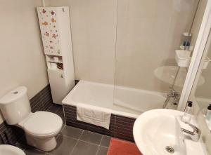 a bathroom with a toilet and a sink and a tub at APARTAMENTO VALMAYOR in Potes