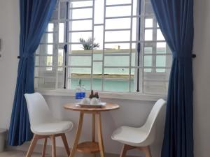 uma mesa e duas cadeiras num quarto com uma janela em Ngoc Diep Homestay Hoi An em Hoi An