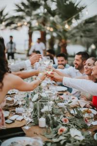 a group of people holding hands at a table at Selvi Beach Hotel in Golturkbuku