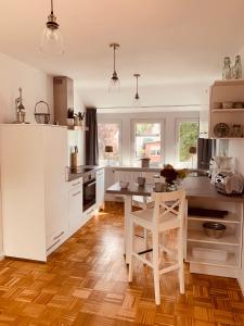 a kitchen with white cabinets and a wooden table at mitten im dorf in Worpswede