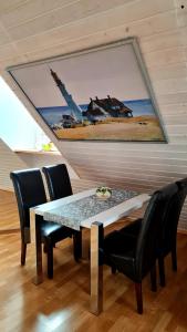 a dining room table with chairs and a painting on the wall at Apartement *Harzblick* in Nordhausen