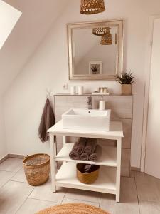 a bathroom with a white sink and a mirror at mitten im dorf in Worpswede