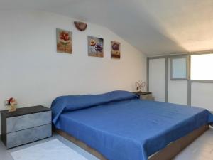ein Schlafzimmer mit einem blauen Bett und einem Fenster in der Unterkunft Casa Elias in Orosei