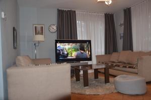 a living room with a tv and a couch and a table at Marta in Okuninka