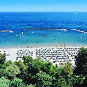 una playa con un montón de gente en el agua en Residence Meeting en Gabicce Mare