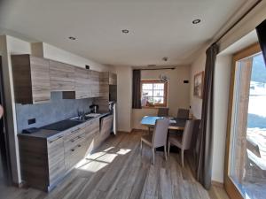 kuchnia ze zlewem i stołem z krzesłami w obiekcie Chalet Pizabela w Livigno