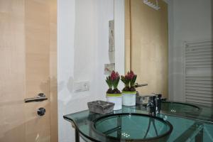 a bathroom with a glass sink with flowers on it at Alp-Hof Apartments in Racines