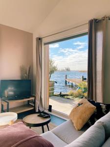 a living room with a large window with a view of the water at Vakantie huis aan het water in Rijpwetering