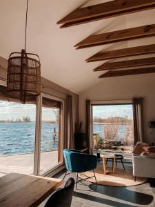 een woonkamer met uitzicht op het water bij Vakantie huis aan het water in Rijpwetering