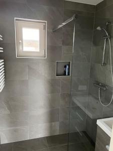 een badkamer met een douche en een glazen deur bij Vakantie huis aan het water in Rijpwetering