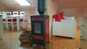 a wood stove in a room with a table and chairs at HERBALIJA Apartment Herbalija - sorrounded by Nature in Podčetrtek