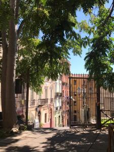una recinzione di fronte a un edificio alberato di casa minù santa chiara a Cagliari