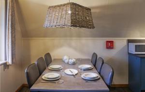 a dining room table with chairs and a chandelier at 3 Bedroom Stunning Home In Gramsbergen in Gramsbergen