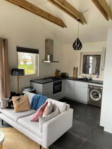 a living room with a couch and a kitchen at Vakantie huis aan het water in Rijpwetering