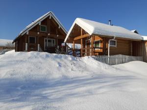 a house with a pile of snow in front of it at Дом с баней на берегу озера in Ferapontovo