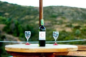 a bottle of wine and two glasses on a table at Glamping Bella Vista in Guatavita