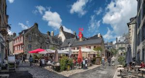 a street with tables and umbrellas in a city at Au COCON QUIMPEROIS in Quimper