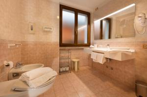 a bathroom with a sink and a toilet and a mirror at Hotel Residence Villa Beatrice in Brenzone sul Garda +46 photos