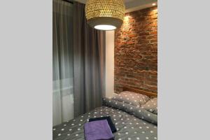 a bedroom with a bed and a brick wall at Koszalin-Old Town Apartment in Koszalin