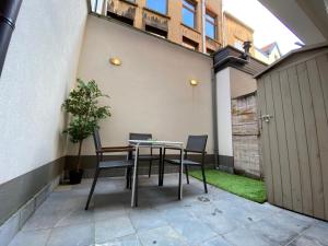 un patio con tavolo e sedie in un cortile di Modern cozy studio with backyard ad Anversa