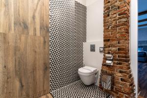 a bathroom with a toilet and a brick wall at Boutique Penzion Slovakia & Slovakia Residence in Košice