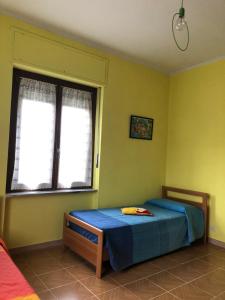 Schlafzimmer mit einem Bett und einem Fenster in der Unterkunft Ca' di Burghi in Busca