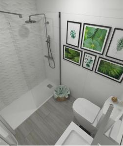 a white bathroom with a shower and a toilet at Guanarteme Vista Surf in Las Palmas de Gran Canaria