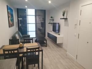a living room with a table and chairs and a television at Guanarteme Vista Surf in Las Palmas de Gran Canaria