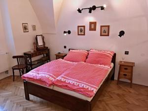 1 dormitorio con 1 cama con mantas rojas y blancas en Apartmány na Trojmezí, byt Leopold, en Slavonice