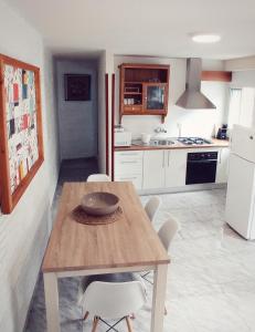 a kitchen with a wooden table and white appliances at La Casa De Mariana in Cazorla