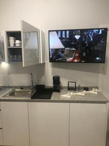 cocina con fregadero y TV en la pared en Apartamentos La Encarnación III en Los Alcázares