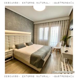 - une chambre avec un grand lit et un bureau dans l'établissement Hotel Rural Peñalabra, à Cervera de Pisuerga
