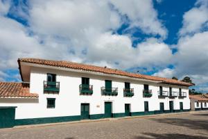 un edificio blanco con techo rojo en Casa La Bisbal, en Cucunubá