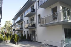 an apartment building with balconies and a courtyard at Apartament Elvira, Grunwaldzka 12C in Pobierowo